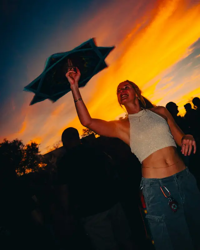 Une danseuse bras levés devant un ciel de coucher de soleil, au Sucre en plein air
