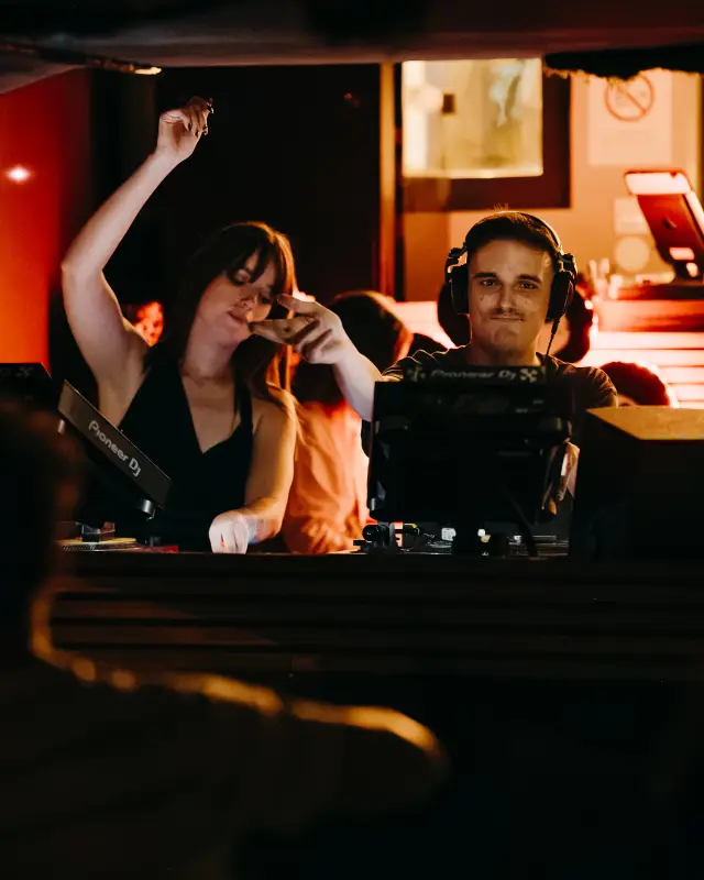 Une danseuse bras levé près de la cabine du DJ, à Frankielanuit!