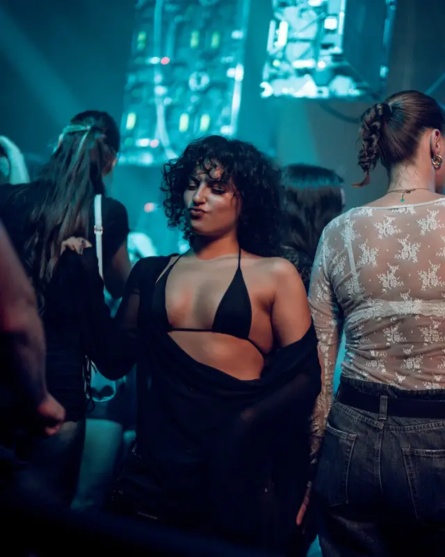 Une danseuse dans la foule du Dieze Warehouse, sous une lumière bleue