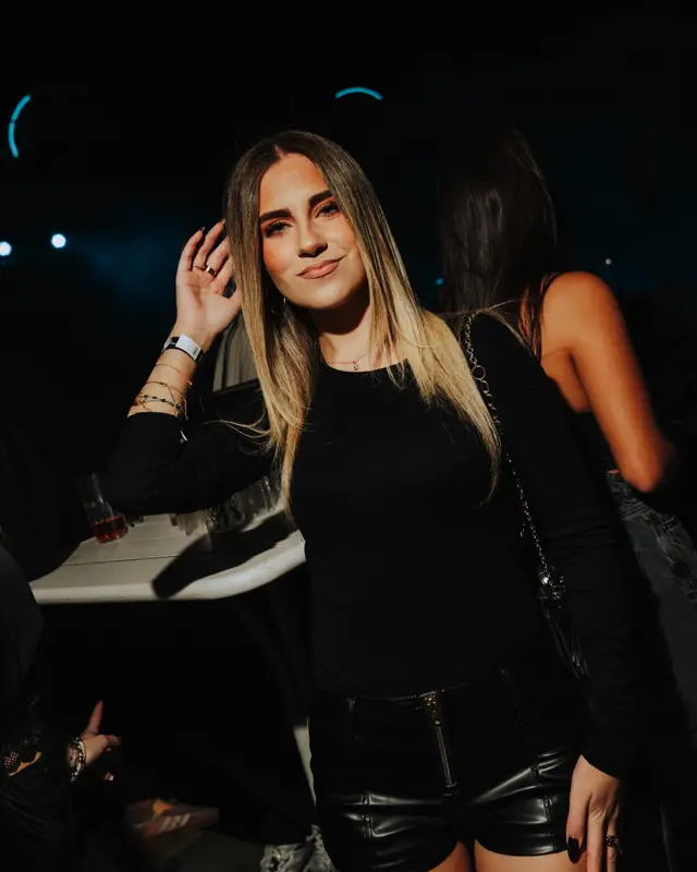 Une jeune femme en tenue noire, main dans les cheveux, sur la piste du R2